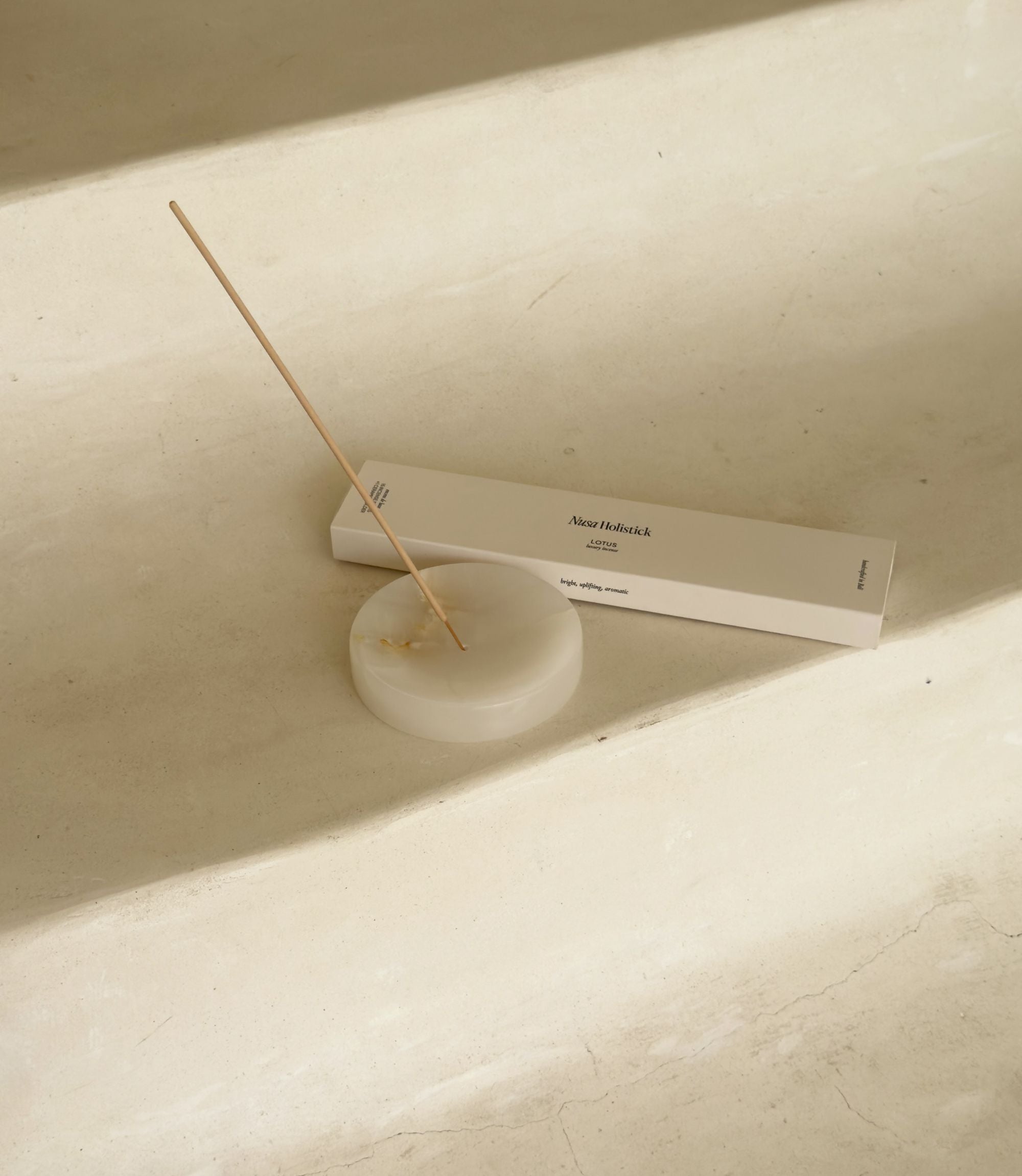 Incense stick and holder on a light-colored surface